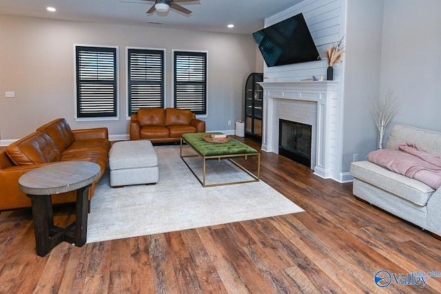 living room featuring dark wood-type flooring and ceiling fan