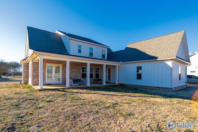 rear view of house with a lawn and a patio