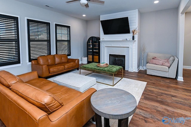 living room featuring a fireplace, dark hardwood / wood-style floors, and ceiling fan