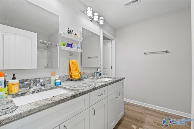 bathroom featuring a shower, vanity, and hardwood / wood-style floors