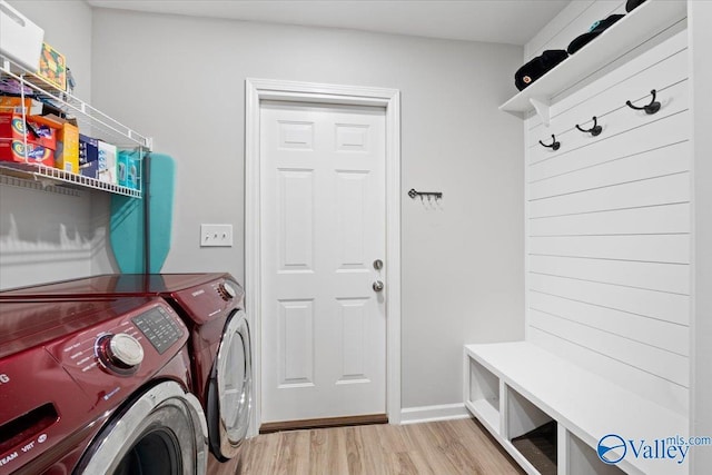 laundry area with washing machine and dryer and light hardwood / wood-style flooring