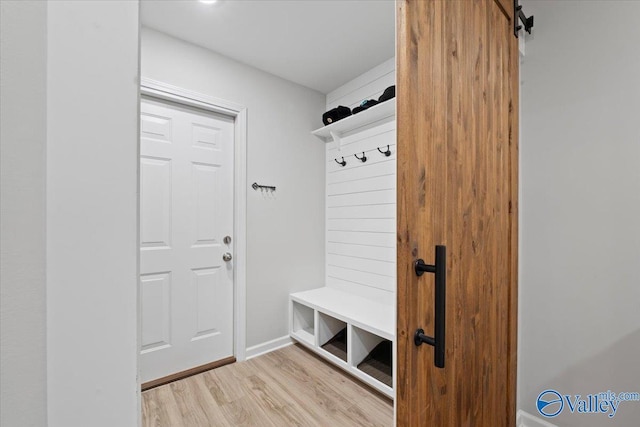 mudroom featuring a barn door and hardwood / wood-style floors