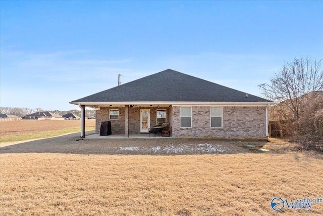 rear view of property with a patio and a lawn