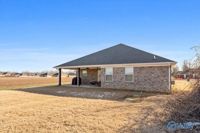 rear view of property featuring a patio area and a yard