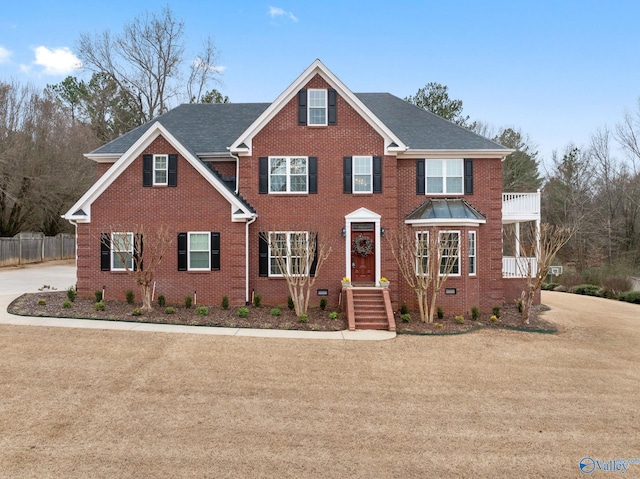 view of front of home featuring a balcony and a front yard