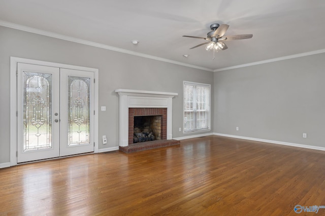 unfurnished living room with crown molding, ceiling fan, wood-type flooring, and a fireplace