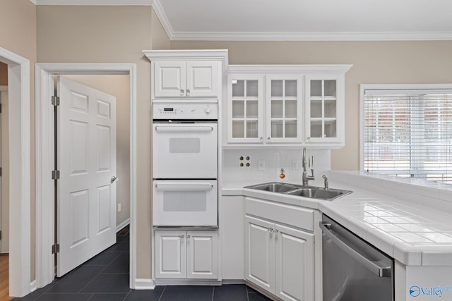 kitchen with white cabinetry, double oven, stainless steel dishwasher, and sink