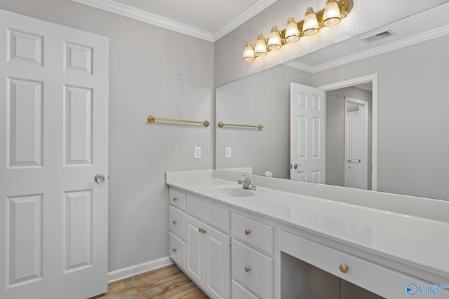 bathroom with vanity, hardwood / wood-style floors, and crown molding