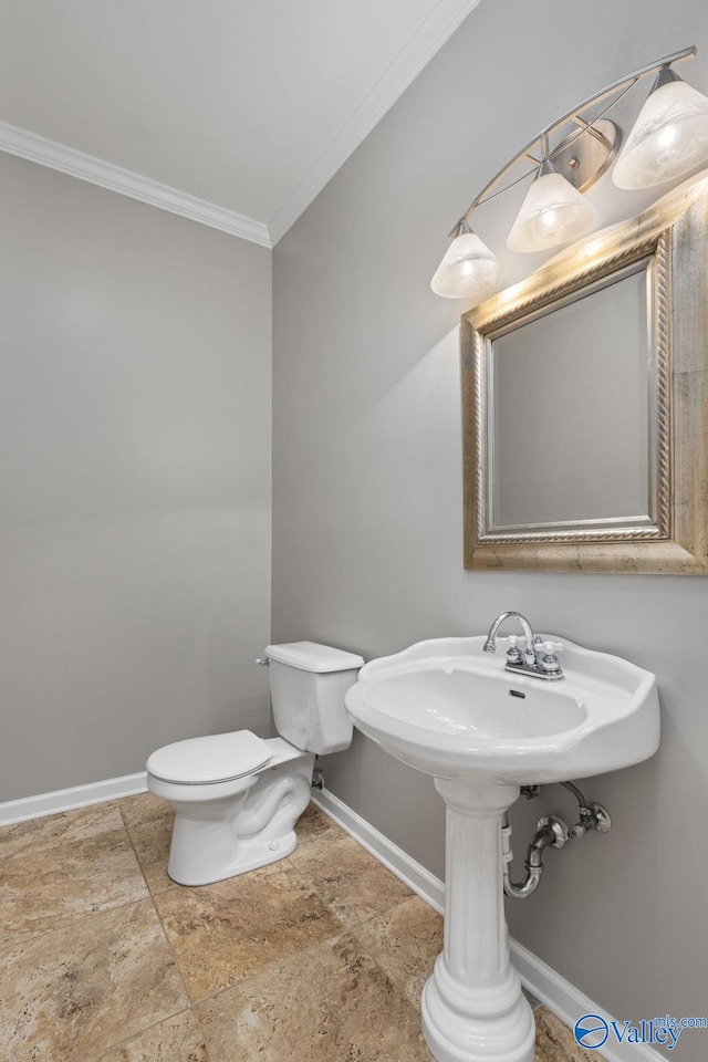 bathroom featuring ornamental molding and toilet