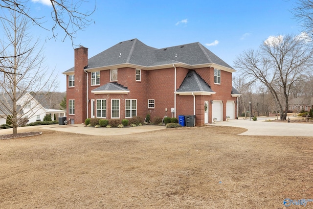 back of house featuring a yard, a garage, and central AC unit