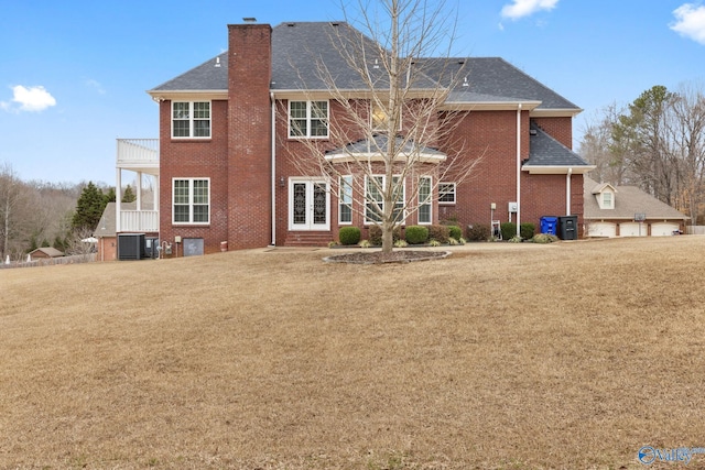 rear view of property featuring a balcony, a yard, and central AC unit