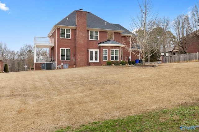 back of property featuring a lawn, a balcony, and central air condition unit