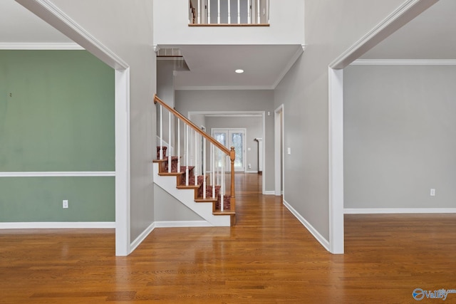 foyer with wood-type flooring and crown molding