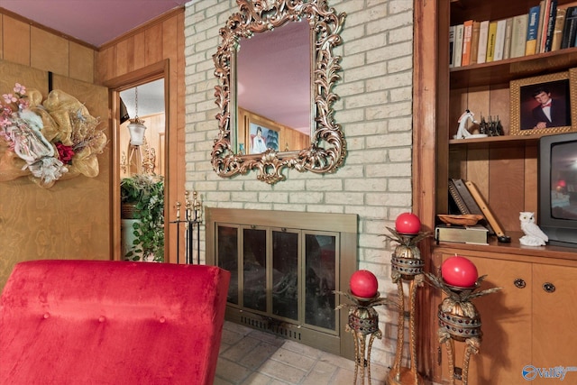 sitting room featuring ornamental molding and a brick fireplace