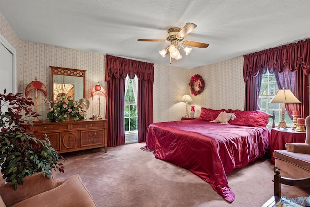 carpeted bedroom with wallpapered walls and ceiling fan