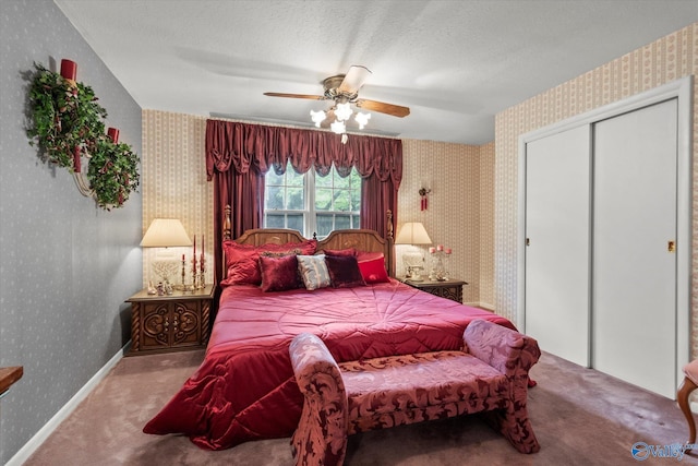 carpeted bedroom with a closet, ceiling fan, baseboards, a textured ceiling, and wallpapered walls