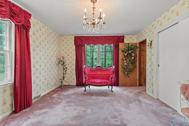 living area with a notable chandelier, visible vents, wallpapered walls, and carpet floors