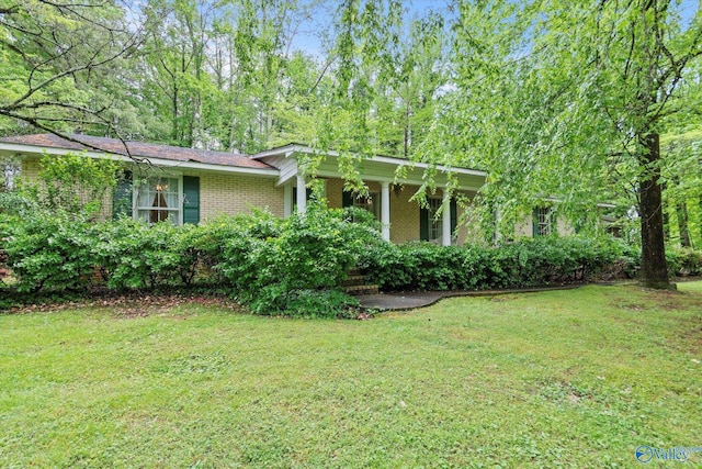 view of front facade with a front lawn, covered porch, and brick siding