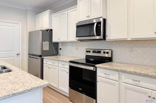 kitchen with tasteful backsplash, ornamental molding, appliances with stainless steel finishes, light stone countertops, and white cabinets