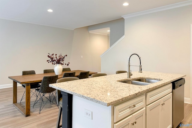 kitchen featuring stainless steel dishwasher, light hardwood / wood-style flooring, sink, and light stone counters