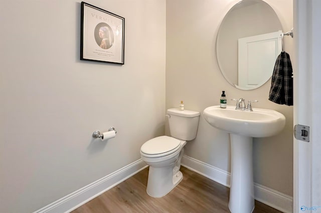 bathroom featuring hardwood / wood-style flooring, toilet, and sink