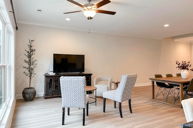 dining space featuring light wood-type flooring, ceiling fan, and crown molding