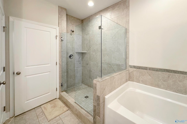 bathroom with tile patterned flooring and independent shower and bath