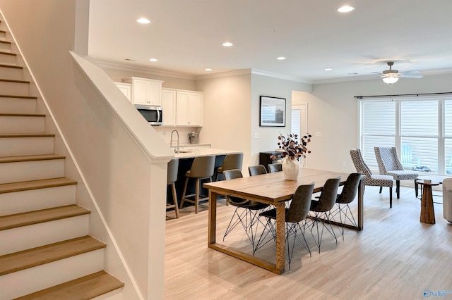 dining room featuring ornamental molding, ceiling fan, and light hardwood / wood-style floors