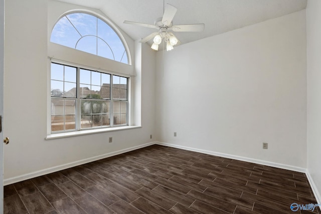 empty room featuring a wealth of natural light, ceiling fan, and dark hardwood / wood-style floors