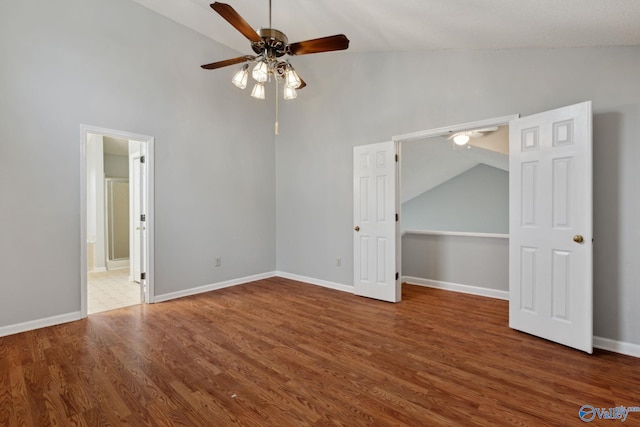 unfurnished bedroom featuring connected bathroom, dark hardwood / wood-style floors, high vaulted ceiling, and ceiling fan