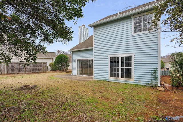 rear view of house featuring a yard and a patio