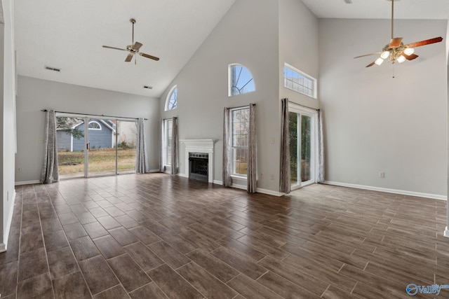 unfurnished living room with a towering ceiling and ceiling fan