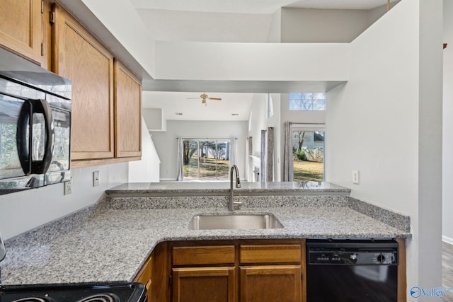 kitchen featuring ceiling fan, dishwasher, sink, light stone counters, and range