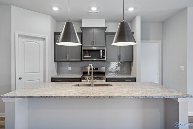 189 Saddle St, New Market, AL 35761 - kitchen with stainless steel appliances, decorative backsplash, a kitchen island with sink, pendant lighting, and gray cabinetry