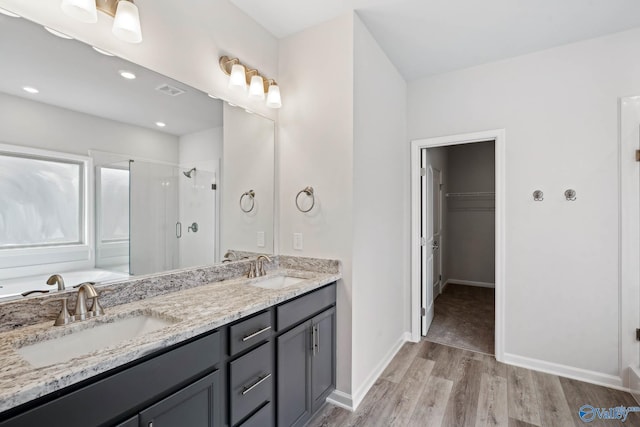 189 Saddle St, New Market, AL 35761 - full bath featuring a stall shower, wood finished floors, a walk in closet, double vanity, and a garden tub