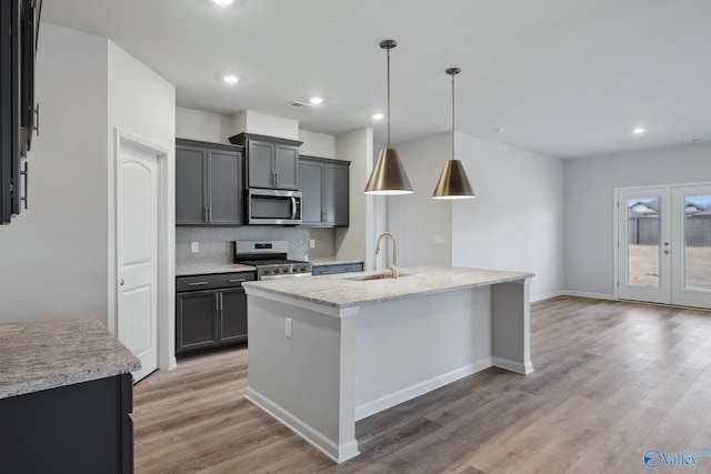 189 Saddle St, New Market, AL 35761 - kitchen featuring stainless steel appliances, light wood finished floors, tasteful backsplash, a kitchen island with sink, and recessed lighting