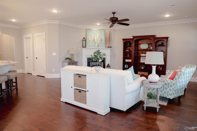 living room with crown molding, ceiling fan, and dark hardwood / wood-style floors