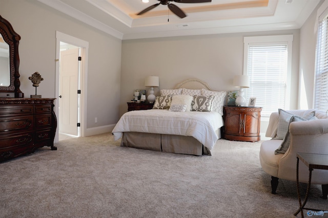 carpeted bedroom featuring ornamental molding, ceiling fan, and a tray ceiling