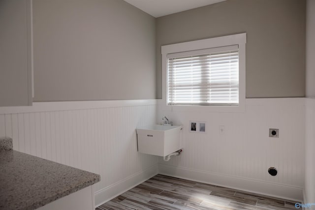 laundry area with sink, hookup for an electric dryer, hookup for a washing machine, and light wood-type flooring