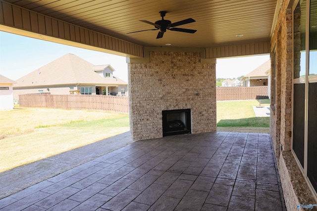 view of patio / terrace with ceiling fan and a fireplace