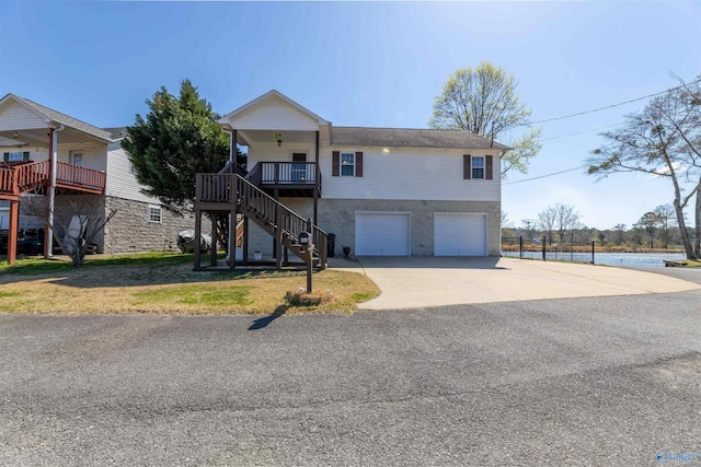 view of front of home with driveway, a front lawn, stairs, a garage, and covered porch