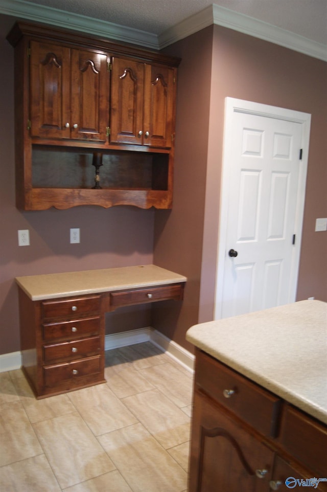 kitchen featuring baseboards, crown molding, and light countertops