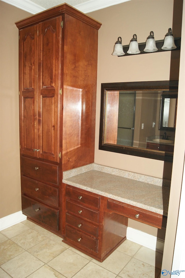 bathroom with tile patterned floors, crown molding, and baseboards