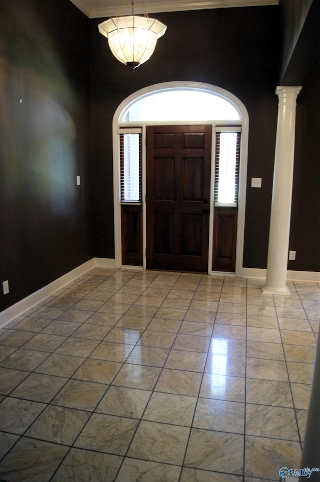 tiled entrance foyer featuring decorative columns and ornamental molding