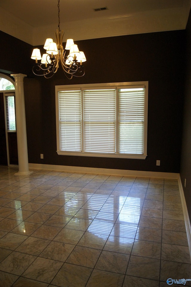 empty room with baseboards, an inviting chandelier, and decorative columns