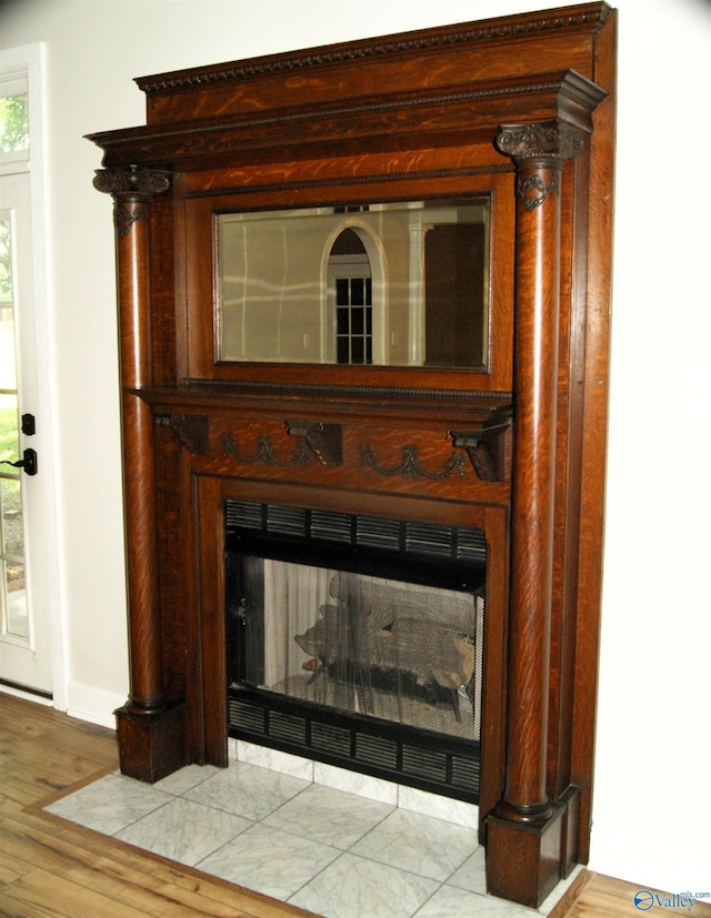 interior details featuring a fireplace with flush hearth and wood finished floors