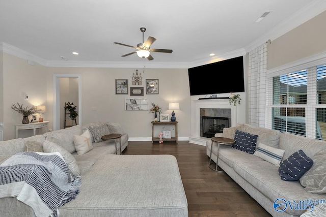 living room featuring crown molding, dark hardwood / wood-style floors, a tile fireplace, and ceiling fan