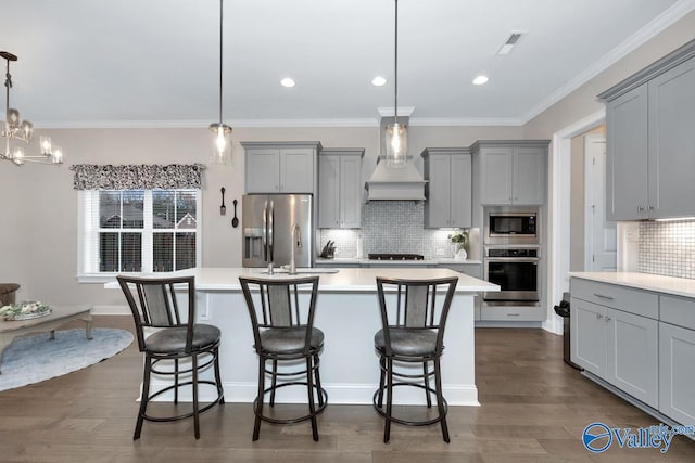 kitchen with appliances with stainless steel finishes, hanging light fixtures, decorative backsplash, dark hardwood / wood-style floors, and custom exhaust hood