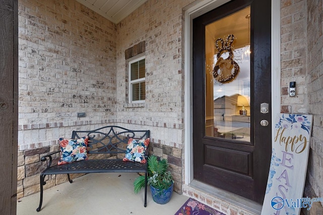 doorway to property featuring brick siding