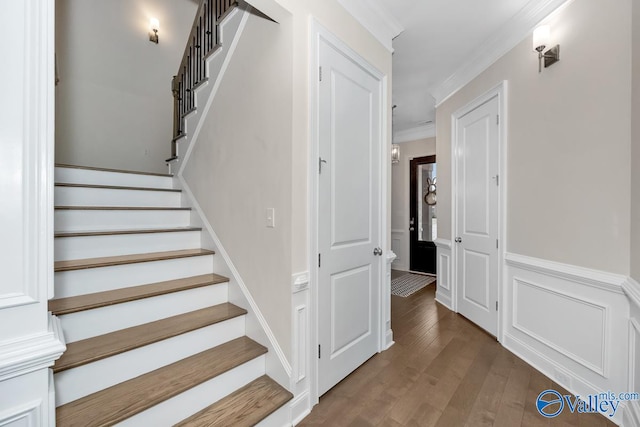 staircase featuring ornamental molding and hardwood / wood-style floors